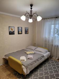 una camera con letto e lampadario a braccio di Sunflower Apartment near Kiev airport & railway station & center city!!! a Kiev