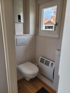a small bathroom with a toilet and a window at Haus mit stilvoller Ferienwohnung und Tiny House nahe Ammersee für 2-6 Personen in Geltendorf