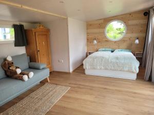 ein Schlafzimmer mit großem Bett und Fenster in der Unterkunft Haus mit stilvoller Ferienwohnung und Tiny House nahe Ammersee für 2-6 Personen in Geltendorf
