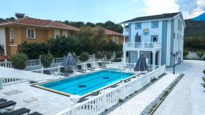 a house with a swimming pool in front of a house at Belinda Apartments in Kemer