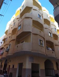 un gran edificio amarillo con ventanas laterales en App12 - RAWDA - Enjoy the privacy of staying in a quiet apartment with free Wi-Fi as your complete second home in the heart of Hurghada, en Hurghada