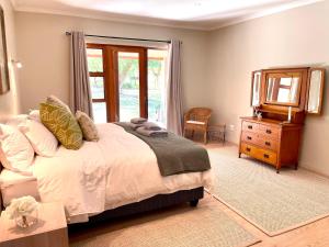 a bedroom with a bed and a mirror and a dresser at Summerplace Game Reserve in Vaalwater