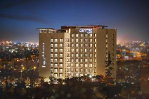 Un edificio con un cartel encima por la noche. en Centro Mada Amman by Rotana, en Amán