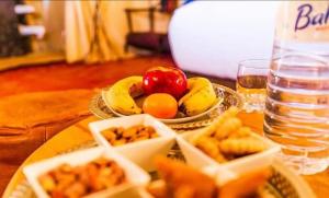 a table with a plate of food and a bowl of fruit at desert camp sahara luxury in Merzouga