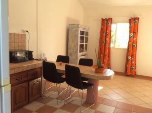 - une cuisine avec une table et des chaises dans la chambre dans l'établissement LA KAZ A DADA, à Sainte-Suzanne