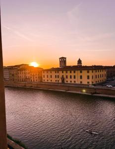 a sunset over a building next to a body of water at Il B&B dei viaggiatori in Pisa