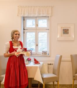 Eine Frau, die vor einem Tisch steht und eine Kiste hält. in der Unterkunft Hotel Domschatz in Quedlinburg