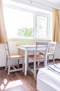 a white table and chairs in a room with a window at Wesselényi Strand apartmanok in Balatonalmádi