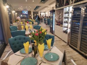 a dining room with a table with flowers on it at Rose Gardens Apart Hotel in Pomorie