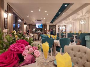 a dining room with a table with flowers on it at Rose Gardens Apart Hotel in Pomorie +44 photos