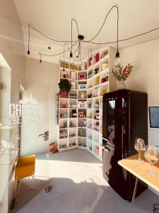 um quarto com um frigorífico e uma mesa com copos de vinho em Camping Zee van Tijd Holwerd em Holwerd