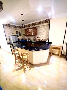 a kitchen with a counter and chairs in a room at شقة بأطلالة علي الشاطئ in Alexandria