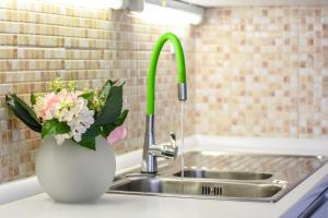 a vase with flowers sitting next to a sink at BARKA in Mandre +12 photos