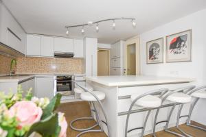 a kitchen with white cabinets and a counter with stools at BARKA in Mandre