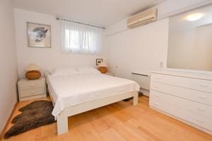 a bedroom with a white bed and a dresser at BARKA in Mandre