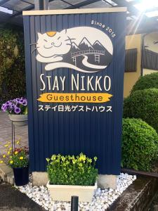 ein Schild für einen Aufenthalt in der Pension nixko guitzko in der Unterkunft Stay Nikko Guesthouse in Nikko