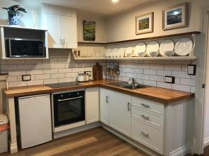 uma cozinha com armários brancos e um lavatório em Silwood Apartment fully self contained with Kitchen and Laundry em Devonport