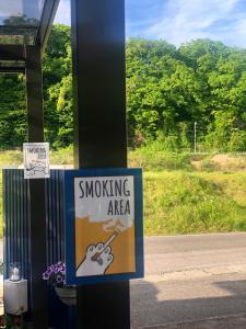 una señal de zona de fumadores en un poste junto a una carretera en Stay Nikko Guesthouse, en Nikko