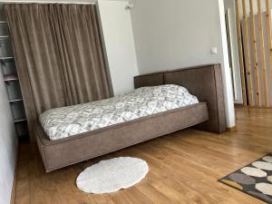a bed sitting in a room with a wooden floor at DEUXx rooms in Liepāja
