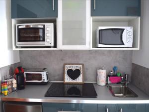 eine Küchentheke mit Mikrowelle und Spüle in der Unterkunft Studio Paraiso in Playa Blanca