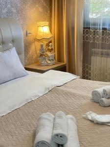 a bedroom with a bed with towels on it at Guest House Royal Comfort With Terrace in Kutaisi +128 photos