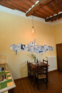 a kitchen with a table with a drawing on the wall at il Cantuccio in Pitigliano