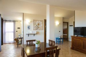 a living room with a dining table and a television at Case I Gerani in Alghero