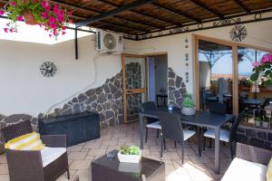 a patio with a table and chairs and a fireplace at Case I Gerani in Alghero