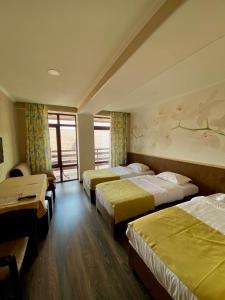 um quarto de hotel com três camas e uma janela em Отель У рыбака em Bosteri