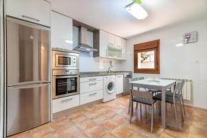 kuchnia ze stołem, lodówką i zlewem w obiekcie URIBE-ENEA Casa sola con amplio patio en Elciego con visita a bodega, siempre sujeta a disponibilidad w mieście Elciego