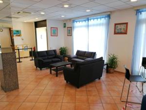 a waiting room with couches and chairs in a lobby at Hotel Palace in Finale Ligure