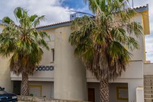 dos palmeras delante de un edificio en Apartamento Pedras Pretas en Porto Santo