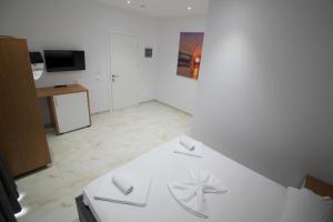 a white room with a bed and a tv at Moonshine Hotel in Ksamil