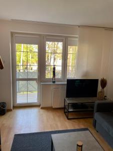 a living room with a couch and two windows at Apartament Giulia in Krynica Morska