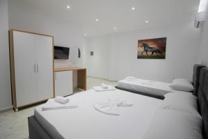 a room with two beds and a mirror at Moonshine Hotel in Ksamil