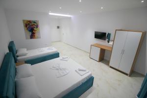 a small room with two beds and a mirror at Moonshine Hotel in Ksamil