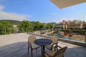 a patio with chairs and a table on a balcony at Moonshine Hotel in Ksamil