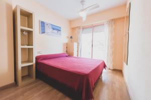 um quarto com uma cama e uma grande janela em Apartamentos Nuevo México C 431 em Calpe