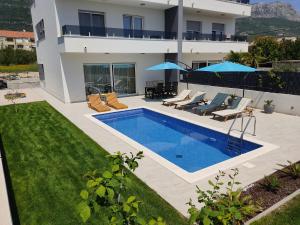 a swimming pool in the backyard of a house at NEW VILLA DAVID, WI-FI, IPTV, 5 bedrooms, 4 bathrooms in Kaštela