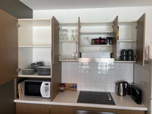 uma cozinha com armários brancos e um micro-ondas em Apartment 3 Wallaroo Marina em Wallaroo