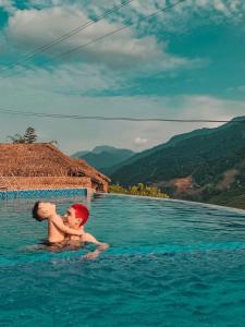 dos niños en una piscina en las montañas en Sapa Eco Villas & Spa, en Sa Pa