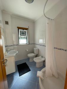 a bathroom with two toilets and a sink and a shower at Zulla Moradia T3, Praia do Norte in Nazaré +20 photos
