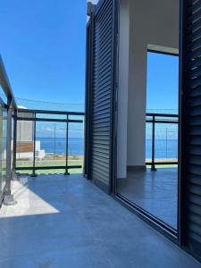 a balcony with sliding glass doors and a view of the ocean at L'Eté sans fin, vue mer in Filaos