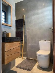 uma casa de banho com um WC e um lavatório em L'Eté sans fin, vue mer em Filaos