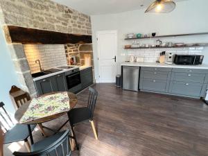 een keuken met blauwe kasten en een tafel en stoelen bij Treignac Place Studio in Treignac