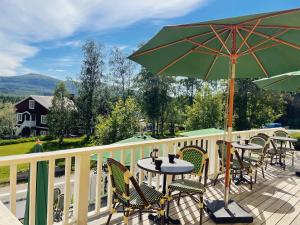 a patio with tables and chairs and an umbrella at Hotell Åre Fjällsätra in Undersåker +85 photos