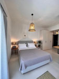 sypialnia z dużym łóżkiem i żyrandolem w obiekcie Fays luxury apartments by the sea w mieście Finikounda