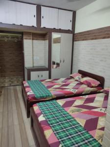 2 Betten nebeneinander in einem Zimmer in der Unterkunft SRI VARI RESIDENCY in Vellore