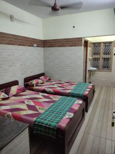 2 Einzelbetten in einem Zimmer mit in der Unterkunft SRI VARI RESIDENCY in Vellore