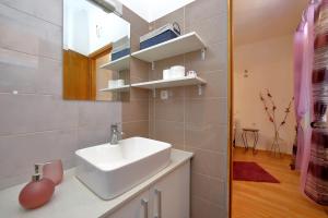 ein Badezimmer mit Waschbecken und Spiegel in der Unterkunft Apartments Ivana Bibinje in Bibinje